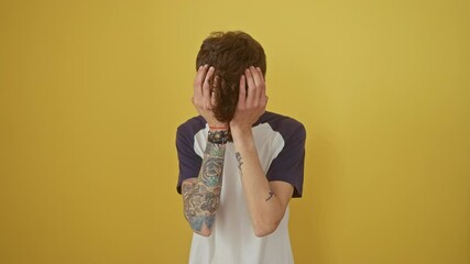 Poster - Stressed young hispanic man suffering from migraine pain, an intense headache and ache, standing isolated over a yellow background