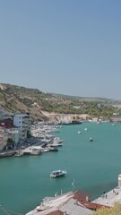 Wall Mural - Bay with beautiful seaside town. Action. Top view of bay with beautiful sea boats and city on shore. Long harbor with seaside town and yachts on sunny summer day