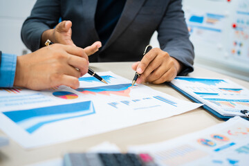 close-up of two professionals' hands meeting at a desk, discussing business strategies over a digital tablet and laptop. teamwork, planning, and communication in a corporate office setting.