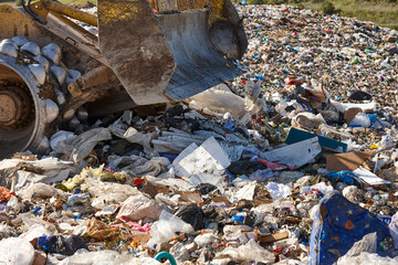 Wall Mural - Heavy machinery shredding garbage in an open air landfill. Pollution