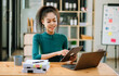 © Nuttapong punna - African businesswoman working in the office with working notepad, tablet and laptop documents .