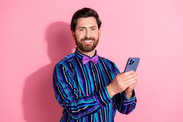 Sticker - Photo of handsome elegant cheerful man wear stylish clothes hold device isolated on pink color background