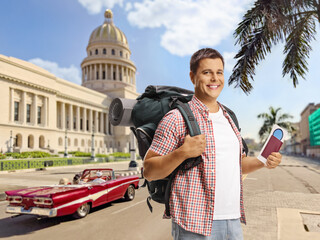 Wall Mural - Male tourist with a backpack holding a passport in Havana