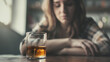 © Bonsales - Glass of whiskey with ice on wooden table with person in background looking down. Scene captures a somber and contemplative mood