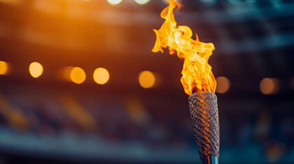 Wall Mural - Fiery olympic torch against blurred sports arena, with text space for creative messaging