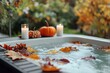 © Larisa - Outdoor hot tub with autumn leaves, candles, and pumpkin decor