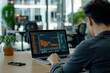 © Ratchpon - Focused on analyzing data, man works on laptop in modern office environment. screen displays financial graphs, reflecting concentration and determination.