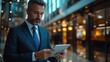 © Attasit - A professional business person in formal attire, working on a tablet in a well-designed office.