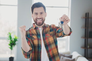 Canvas Print - Photo of attractive young male winning hold house key wear checkered shirt cozy day light home interior living room