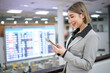 © Treerat - A woman is looking at her phone in a busy airport