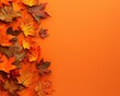© Mikki Orso - Top view of vibrant autumn leaves on orange background with ample space for adding text overlay