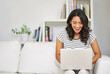 © peopleimages.com - Laptop, happy and woman in home with research for creative freelance project with public relations career. Laugh, technology and female brand manager reading report for client feedback in apartment.
