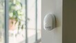© VK Studio - A sleek white motion sensor mounted on a wall in a bright room filled with natural light, symbolizing modern home security and smart living.