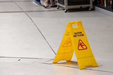 Wall Mural - A yellow caution sign is on the floor