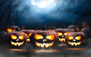 Wall Mural - A collection of glowing halloween pumpkins, spooky Jack O' Lanterns, with copy space above on a scary halloween night.