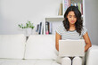 © peopleimages.com - Laptop, sofa and woman in home with research for creative freelance project with public relations career. Typing, technology and female brand manager reading report for client feedback in apartment.