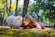 © kamonrat - Young Woman Relaxing in the Park with Her Smiling Pomeranian Dog, Enjoying a Warm Sunny Day Amidst the Tranquil Autumn SceneryKeywords: woman, Pomeranian, dog, park, autumn, sunny, relaxing, nature,