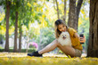 © kamonrat - Woman Capturing a Sweet Selfie with Her Pomeranian in a Beautiful Park, Surrounded by Nature and Golden Leaves