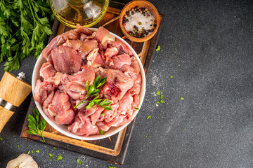 Veal, beef red meat raw chopped goulash, with herbs, condiment, olive oil and spices, cooking dinner background copy space