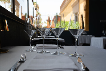 Table prepared to receive diners in a restaurant, with white tablecloth and white background