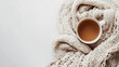 © Matthias - Cozy knitted blanket and cup of tea on clean background, ideal for relaxation or self-care content