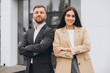 © anatoliycherkas - Portrait of a team and partners of a young business man and woman standing outside the office center with crossed arms, smiling and confidently looking at the camera.