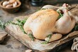 © Kamarizal Kamarludin - A raw whole chicken seasoned and garnished with fresh rosemary, placed on parchment paper, ready for cooking, highlighting freshness and culinary preparation.