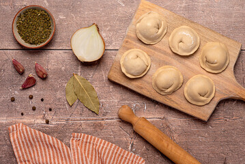 Food photography of ingredients of  homemade dumplings, raw dough and minced chicken, onion, garlic, pepper, bay leaf, ravioli, tortellini