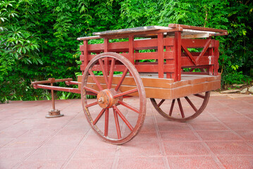 Old cart, horse-drawn means of transportation, historical object displayed in an outdoor garden area in a city in Latin America.