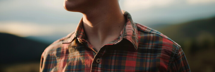 Young Man Wearing Plaid Shirt Outdoors at Sunset in Nature