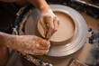 © Cavan Images - Girl is using a pottery scrapper to smooth the edges of a clay p