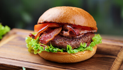 Wall Mural - Delicious homemade beef burger with bacon and vegetables on wood serving board. Tasty food.