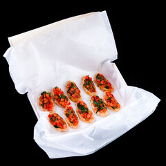 Wall Mural - Bruschetta with with tomatoes and herbs in a paper box.