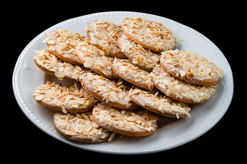 Poster - Dessert shortcrust pastry cookies with cream and almonds on a white plate.