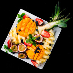 Poster - Fresh fruit and berry plate with mango, pineapple, passion fruit, strawberry, blueberry and mint.