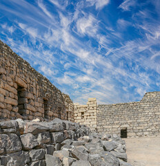 Ruins of Azraq Castle (Qasr al-Azraq) is a crusader castle (300AD),  central-eastern Jordan, 100 km east of Amman, Jordan. Against the background of a beautiful sky with clouds