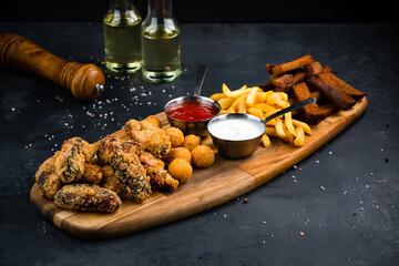 Fresh snacks breaded mozzarella cheese balls, rye bread croutons, French fries, fried meat and sauces.