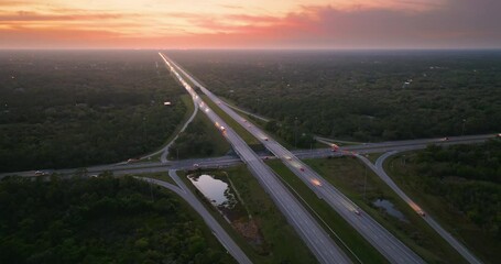 Wall Mural - USA highway transportation infrastructure. American freeway junction in Florida with fast driving cars at sunset