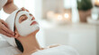 © forenna - A beautician applying a white clay mask to the face of a beautiful young woman in a beauty salon, emphasizing spa treatments and relaxation. photo