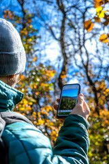 Sticker - Person taking a photo of fall foliage with a phone