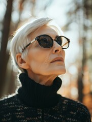 Canvas Print - A woman in sunglasses looks up at the sun. AI.