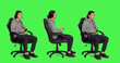 © DC Studio - Asian person plays with controller while seated on chair against a full body greenscreen backdrop. Man engages in electronic gaming adventure with colleagues, gamer performs online games.