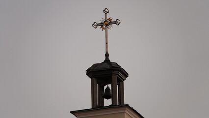 A close-up of the golden cross of the Orthodox Church against the gray sky. Orthodox cross made of gold on the dome of a church in Russia.