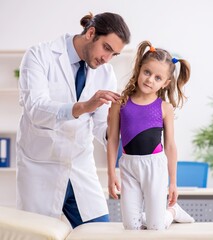 Wall Mural - Small girl visiting young male doctor