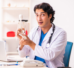 Wall Mural - Young male doctor with skeleton