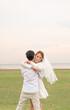 © topntp - Happy young Asian couple in bride and groom clothing