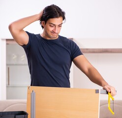 Wall Mural - Young man repairing furniture at home