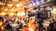 © Tanicsean - A professional cinema camera on a tripod focused on capturing a lively event in a banquet hall, with blurred guests in the background