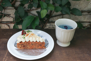 Wall Mural - carrot cake with cream and walnut topping , carrot cake and butterfly pea tea