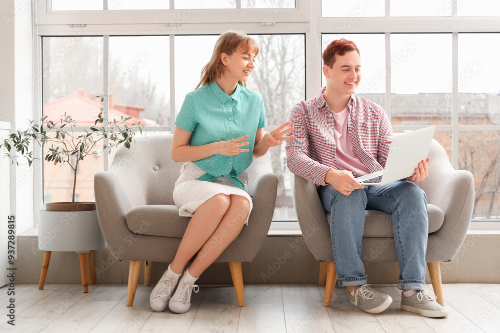Young deaf mute couple video chatting in sign language at home